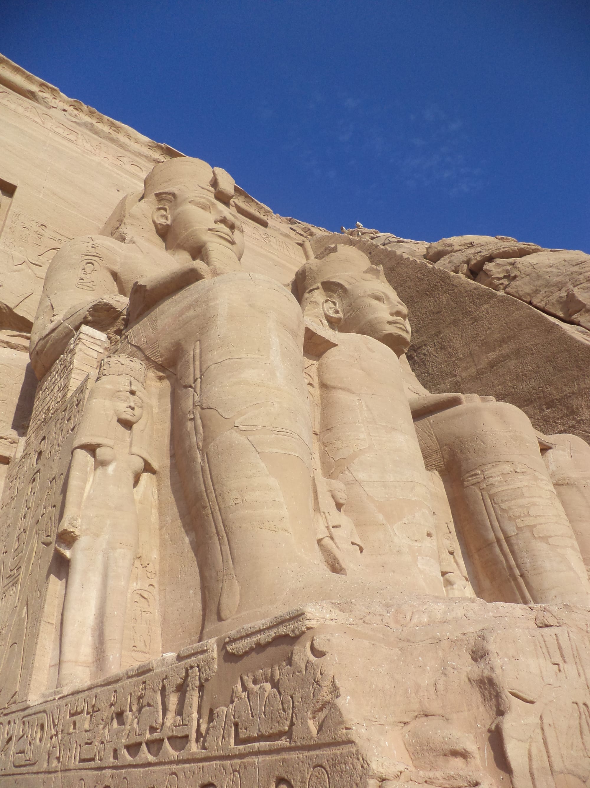 Two of the colossal seated statues of Ramesses II on the facade of the Great Temple at Abu Simbel, southern Egypt.